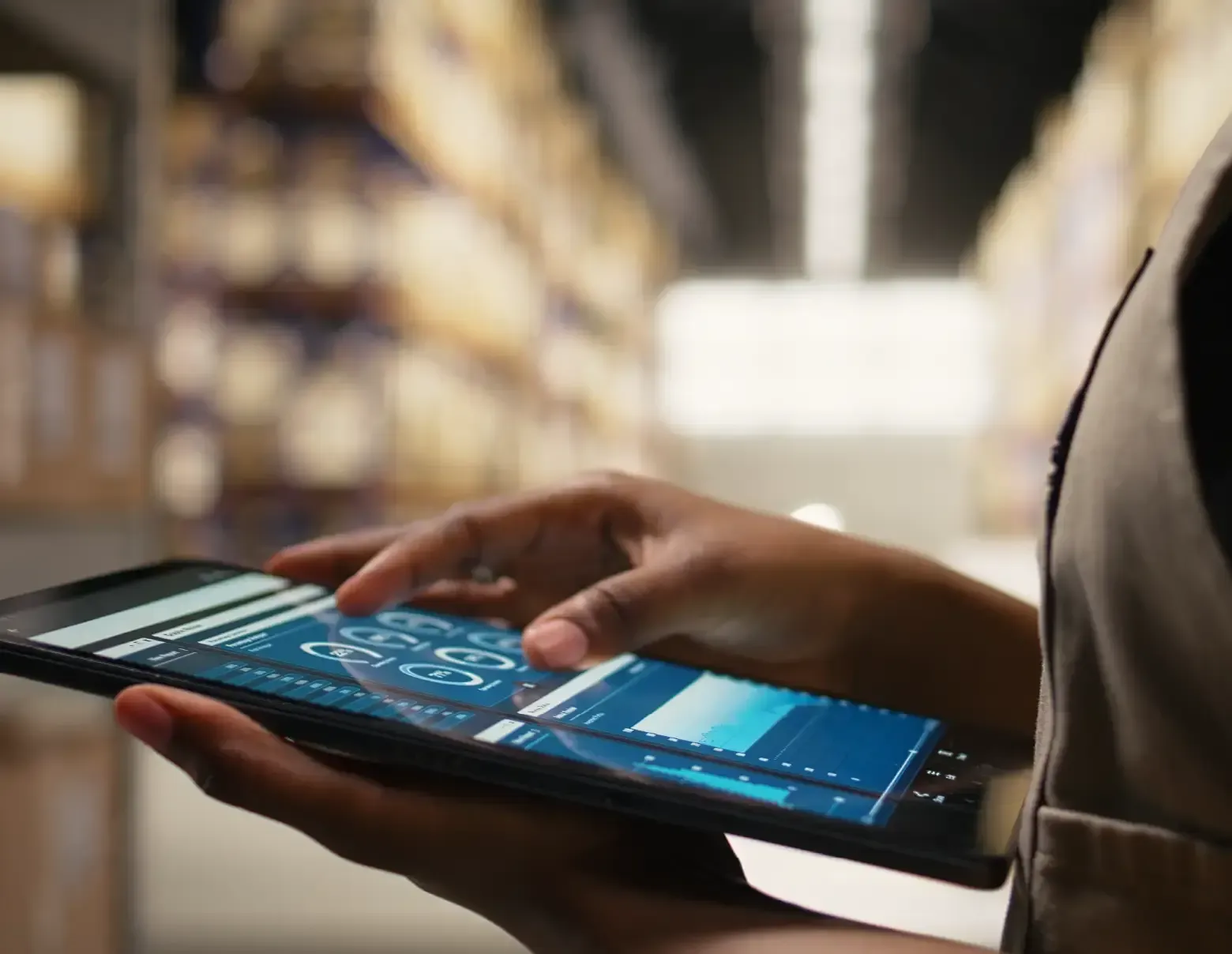 Pessoa utilizando um tablet em ambiente de armazenagem, com interface digital de dados e indicadores