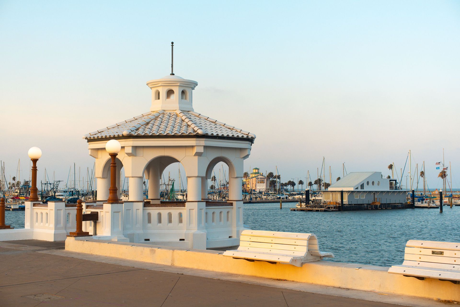 A white gazebo is sitting next to a body of water.