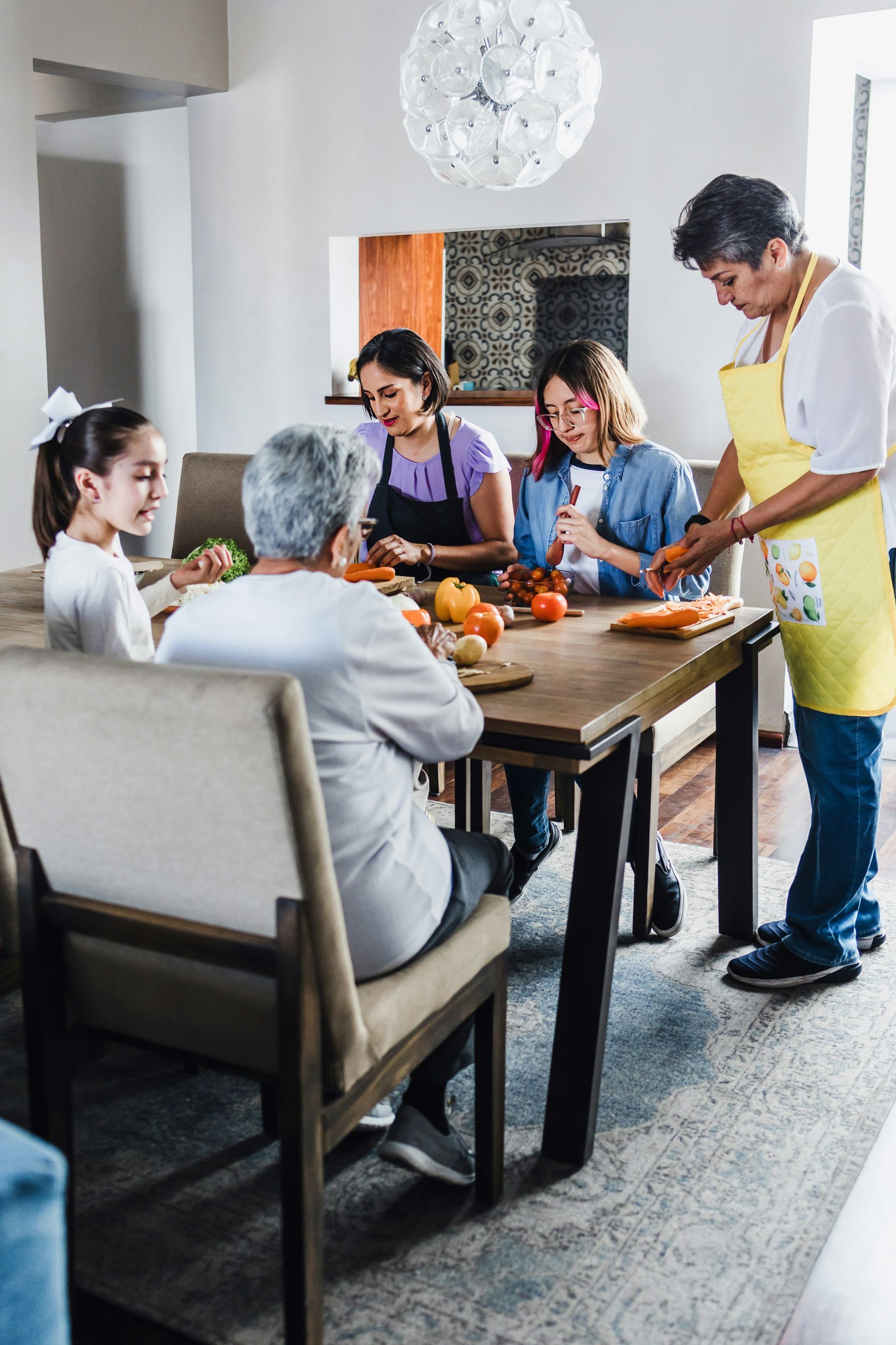 A family is sitting at a table preparing food.