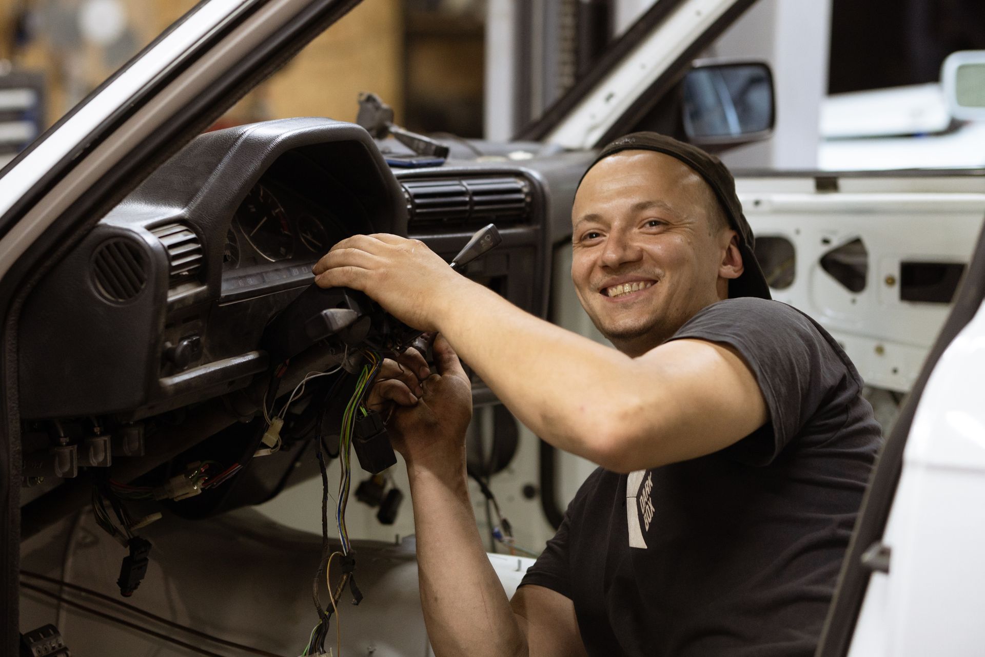 A man is working on the dashboard of a car.