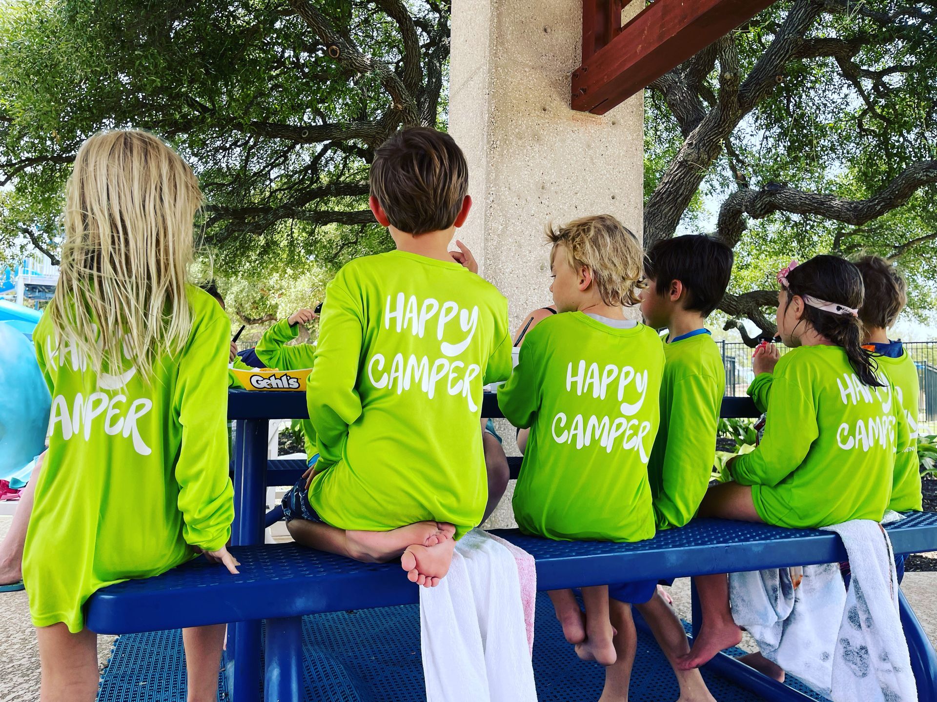A group of children wearing green shirts that say happy campers