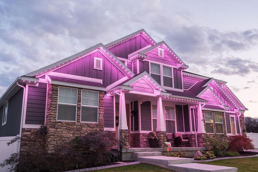 A purple house with pink lights on the roof.