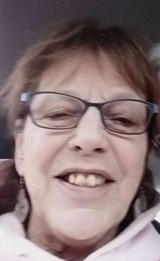 A close up of a woman wearing glasses and smiling.