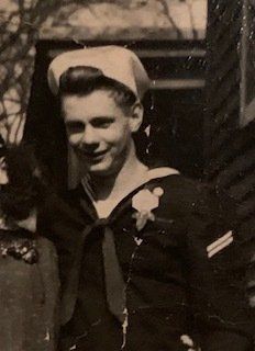 A black and white photo of a young man in a sailor 's uniform.