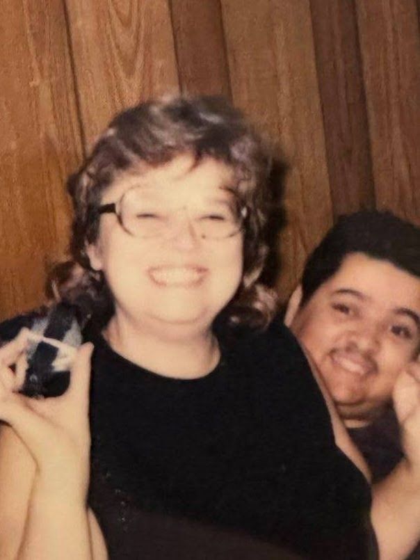 A woman is taking a picture of a man with a camera.