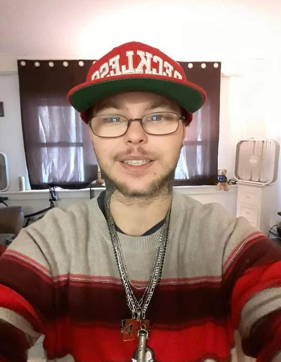 A man wearing glasses and a hat with the word ecket on it