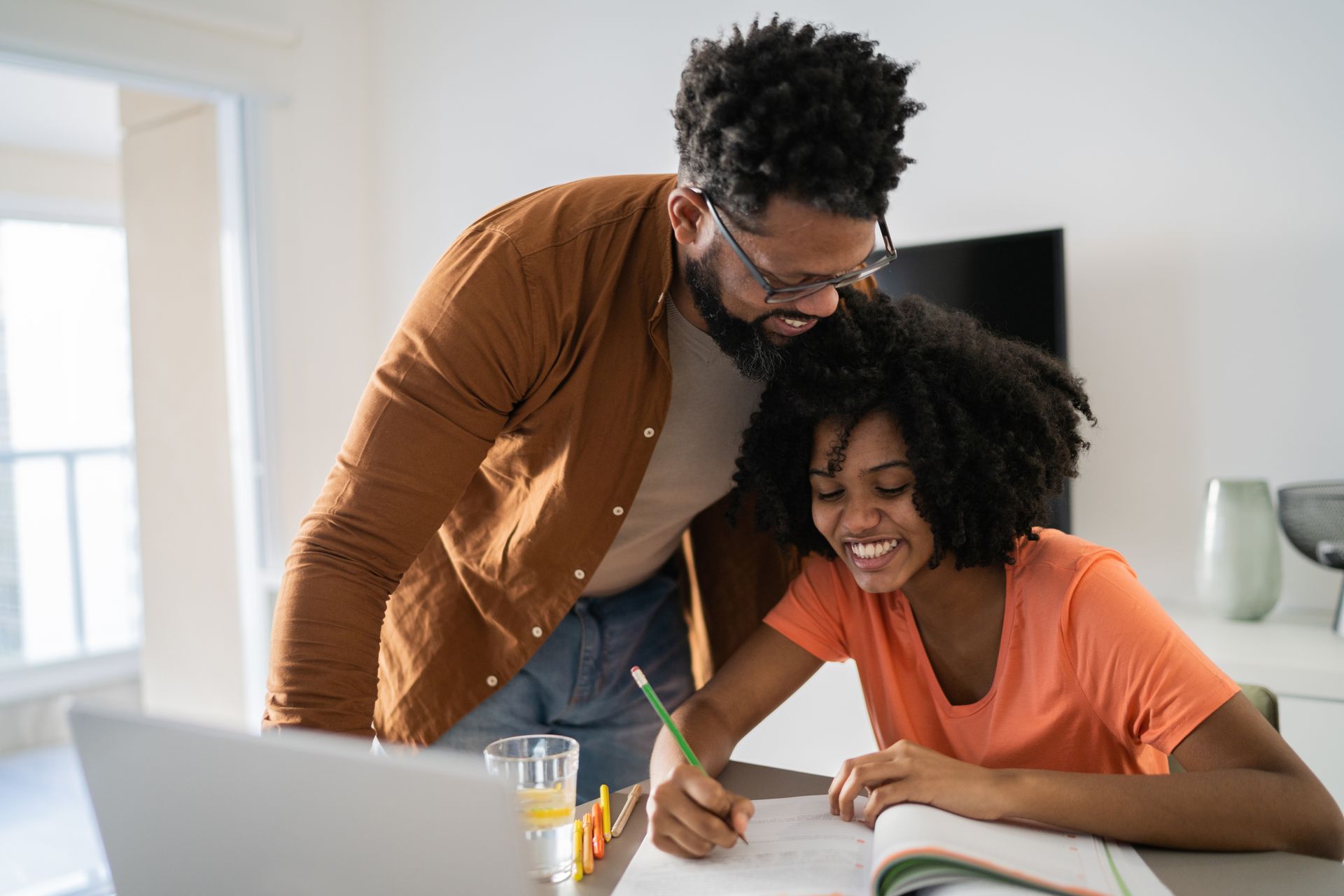 A man and a woman are sitting at a table with a laptop.