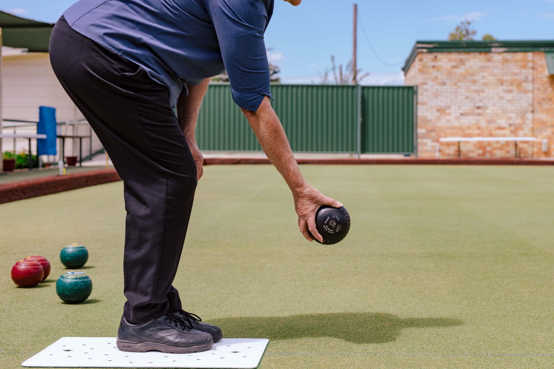 A person is playing a game of lawn bowls