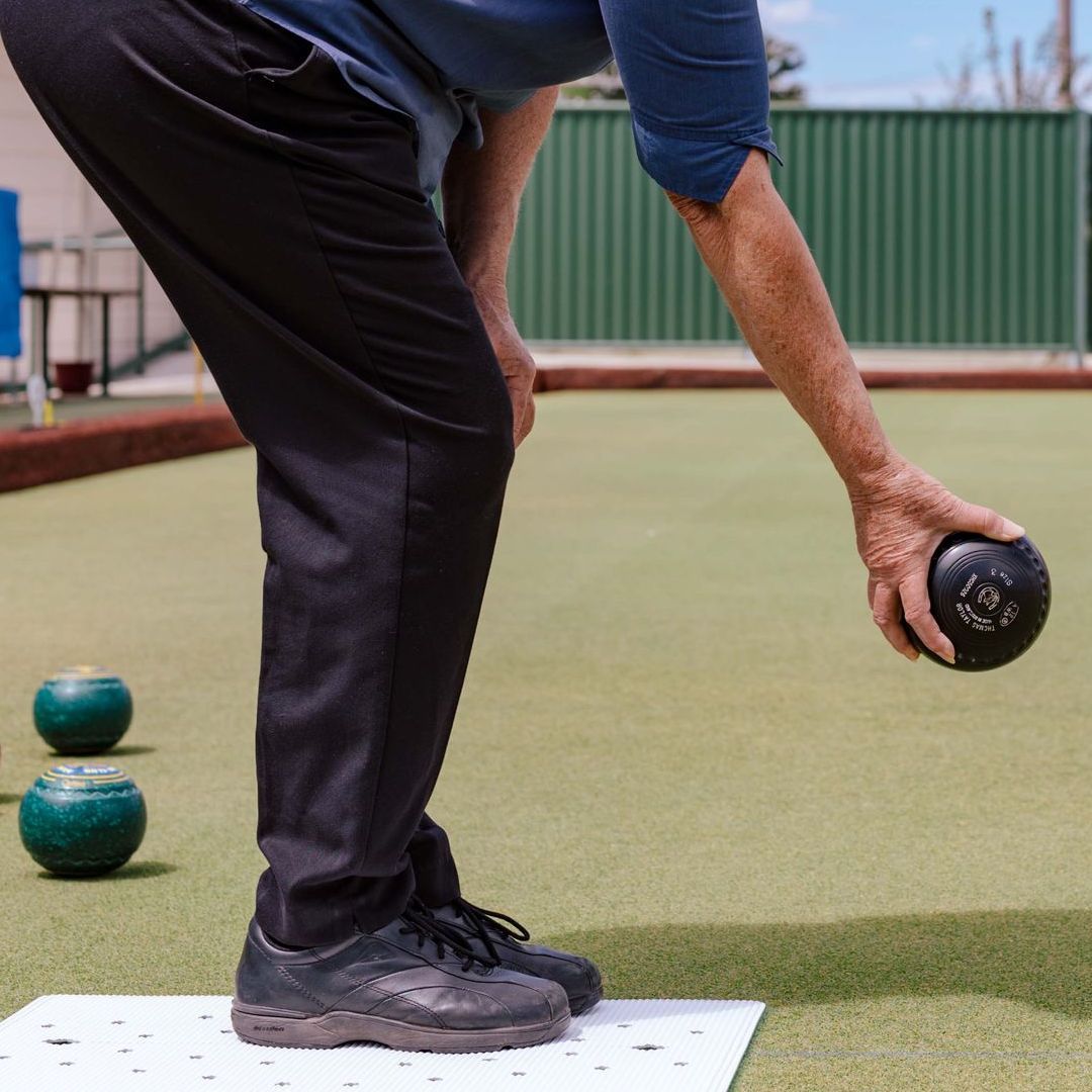 A person is playing a game of lawn bowling