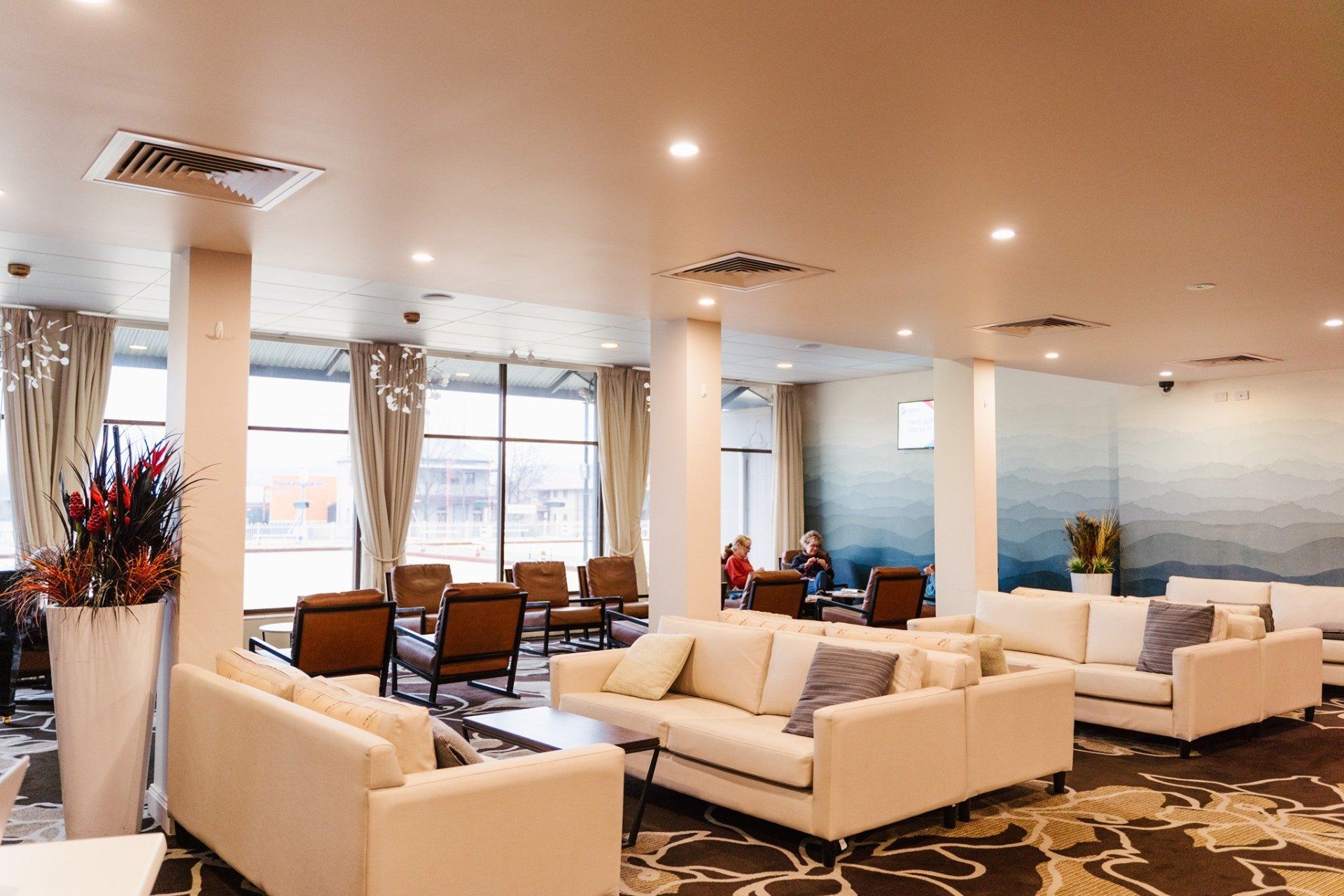 A room with a lot of white couches and chairs