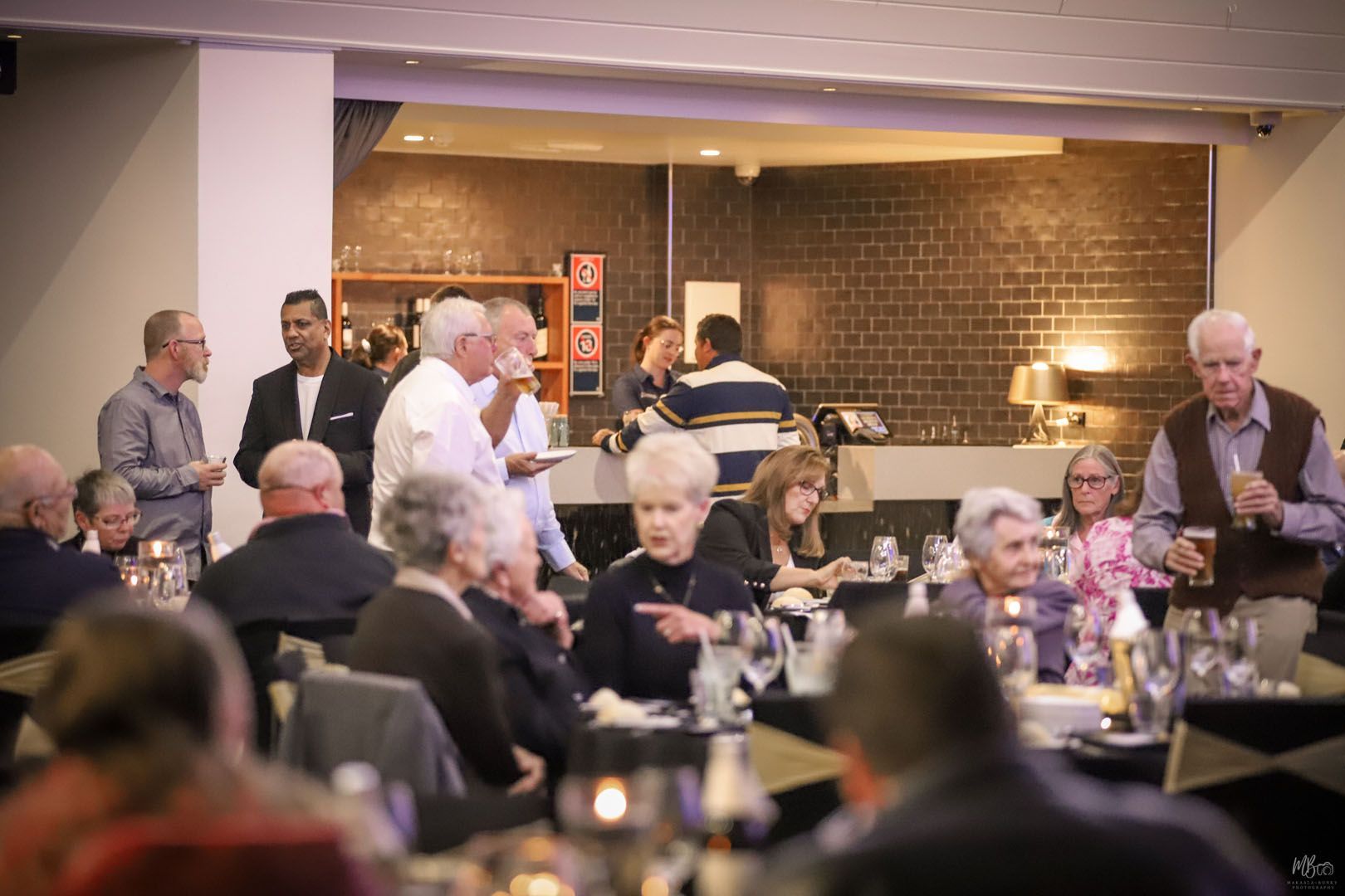 A group of people are sitting at tables in a restaurant