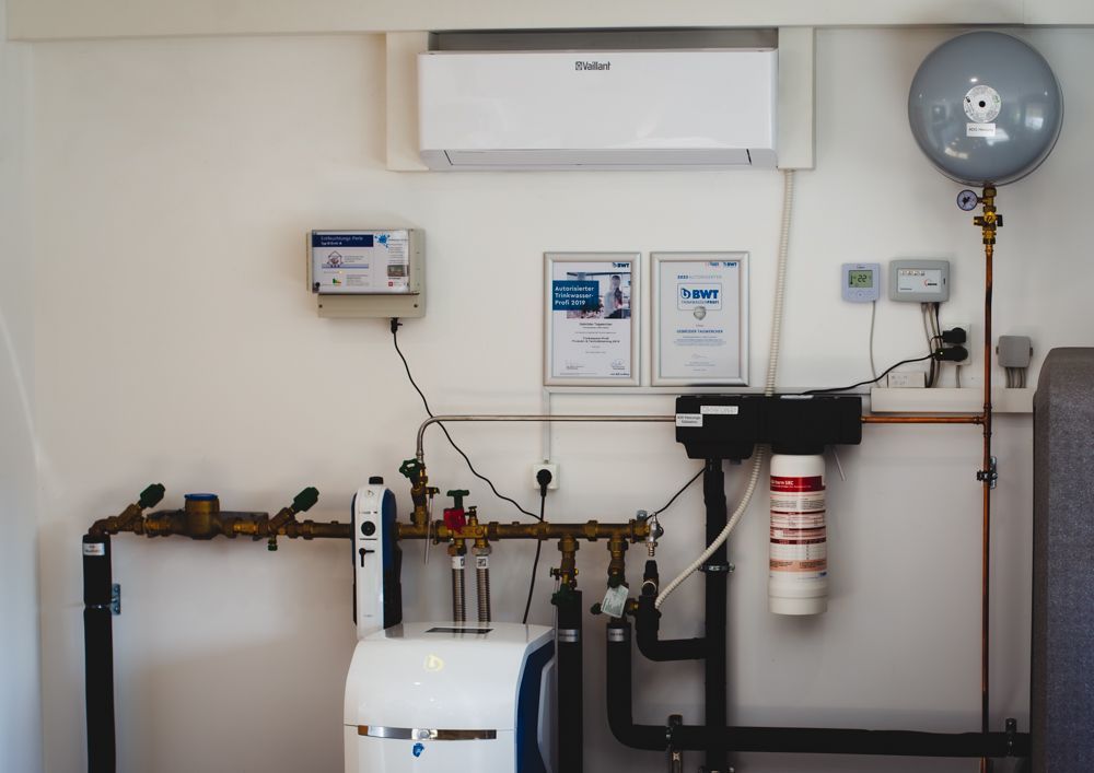 Ein Raum mit vielen Rohren und einer an der Wand montierten Klimaanlage