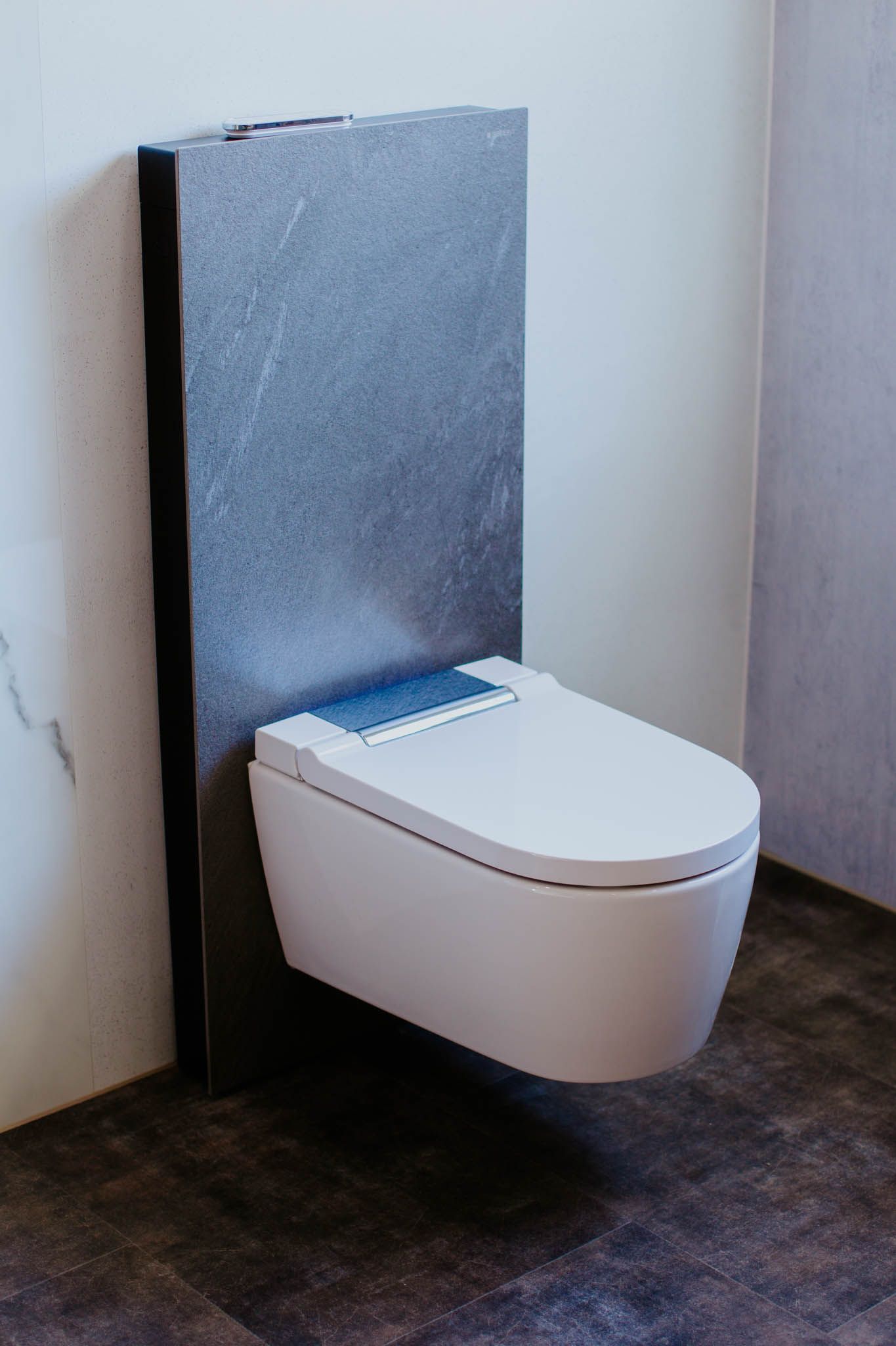 Eine weiße Toilette hängt an einer Wand in einem Badezimmer.