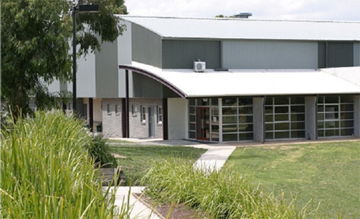 a large building with a white roof is surrounded by grass and trees .