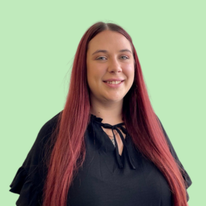 a woman with long red hair is wearing a black shirt and smiling .