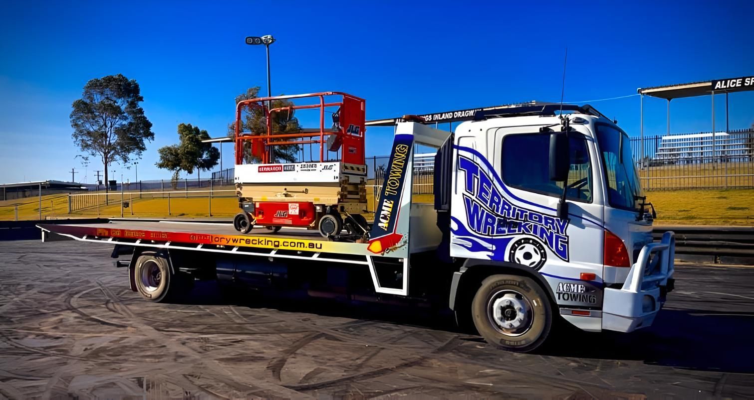 A Tow Truck With A Lift On The Back Is Parked In A Parking Lot — Territory Wrecking Repairs In Alice Springs, NT