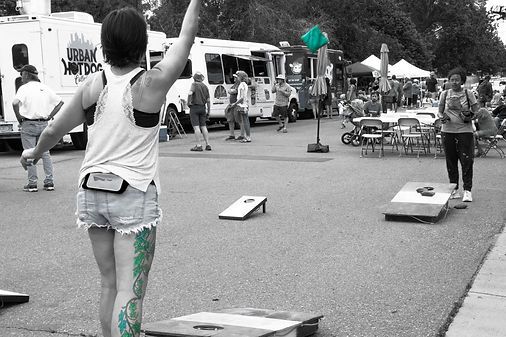A woman is playing a game of bean bag toss in a black and white photo
