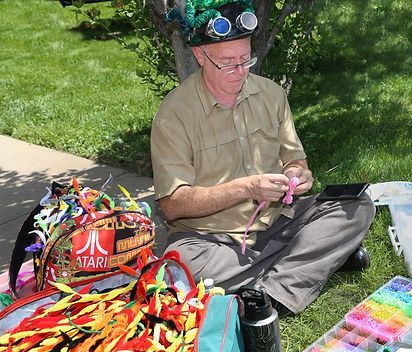 A man is sitting on the grass next to a bag that says atari