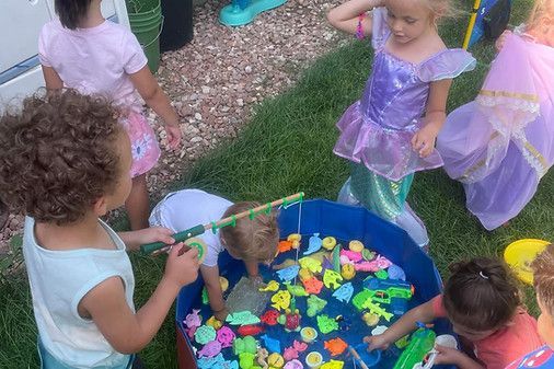 A group of children are playing with fishing rods in a pool.