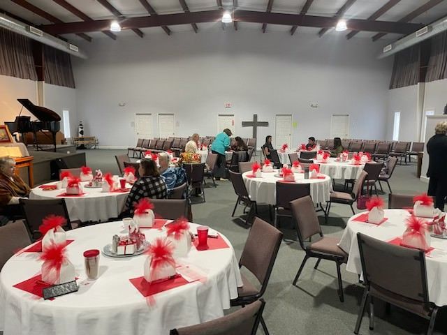 a large room with tables and chairs and a piano