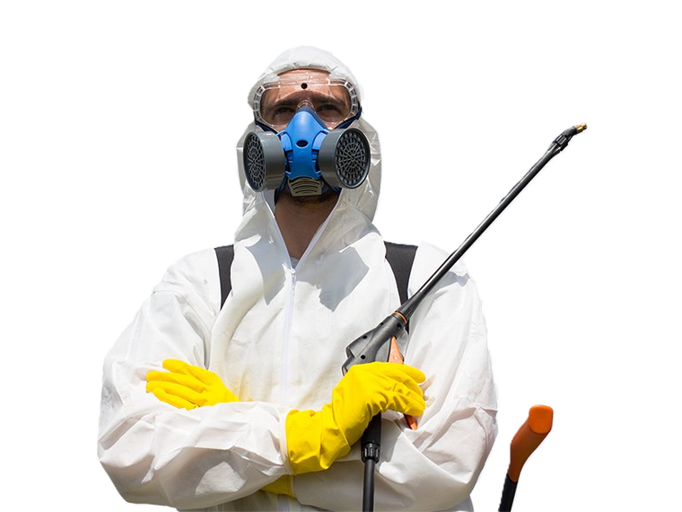 Person in white protective suit, gas mask, and yellow gloves holding a sprayer wand