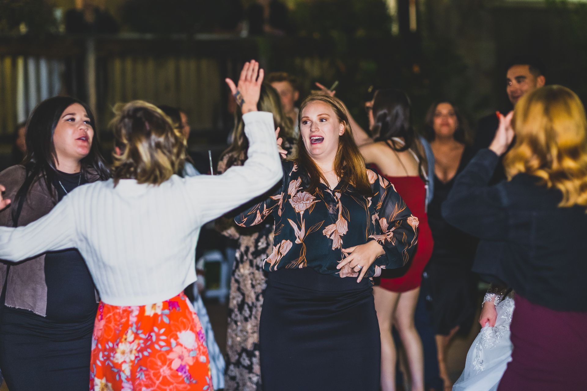 A group of women are dancing together at a wedding.