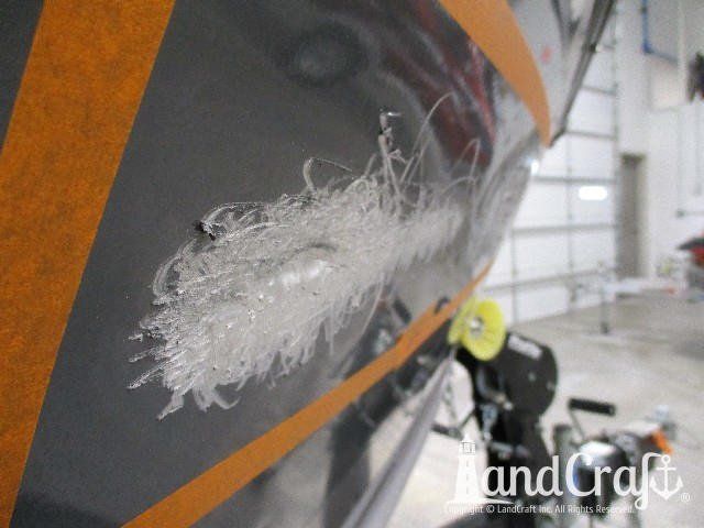 Close up picture of scratches through paint on an aluminum Lund boat