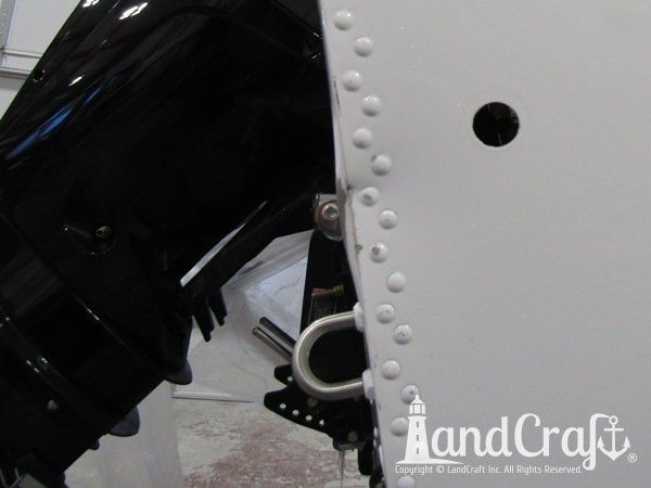 Aluminum Lund boat with dent at transom corner