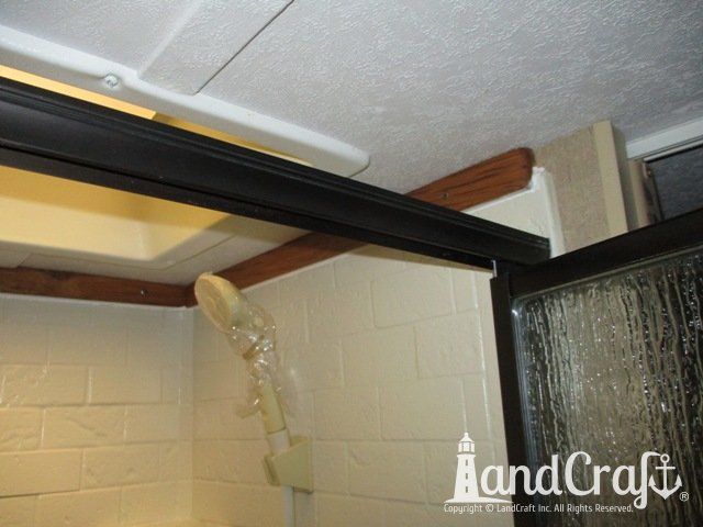 Forest River RV with custom teak finish work above repaired bathroom enclosure