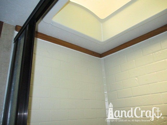 Forest River RV with custom teak finish work above repaired bathroom enclosure