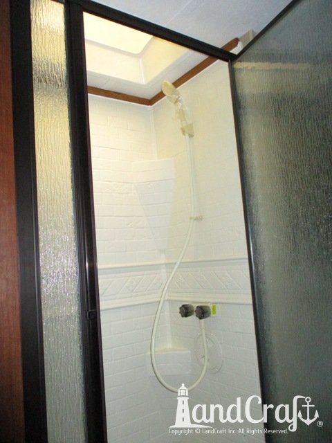 Forest River RV with custom teak finish work above repaired bathroom enclosure