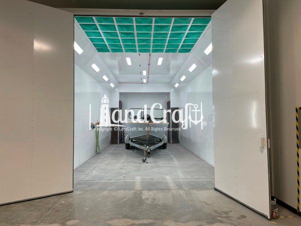 Picture of the repaired aluminum Hewescraft boat in the LandCraft paint booth ready for refinishing