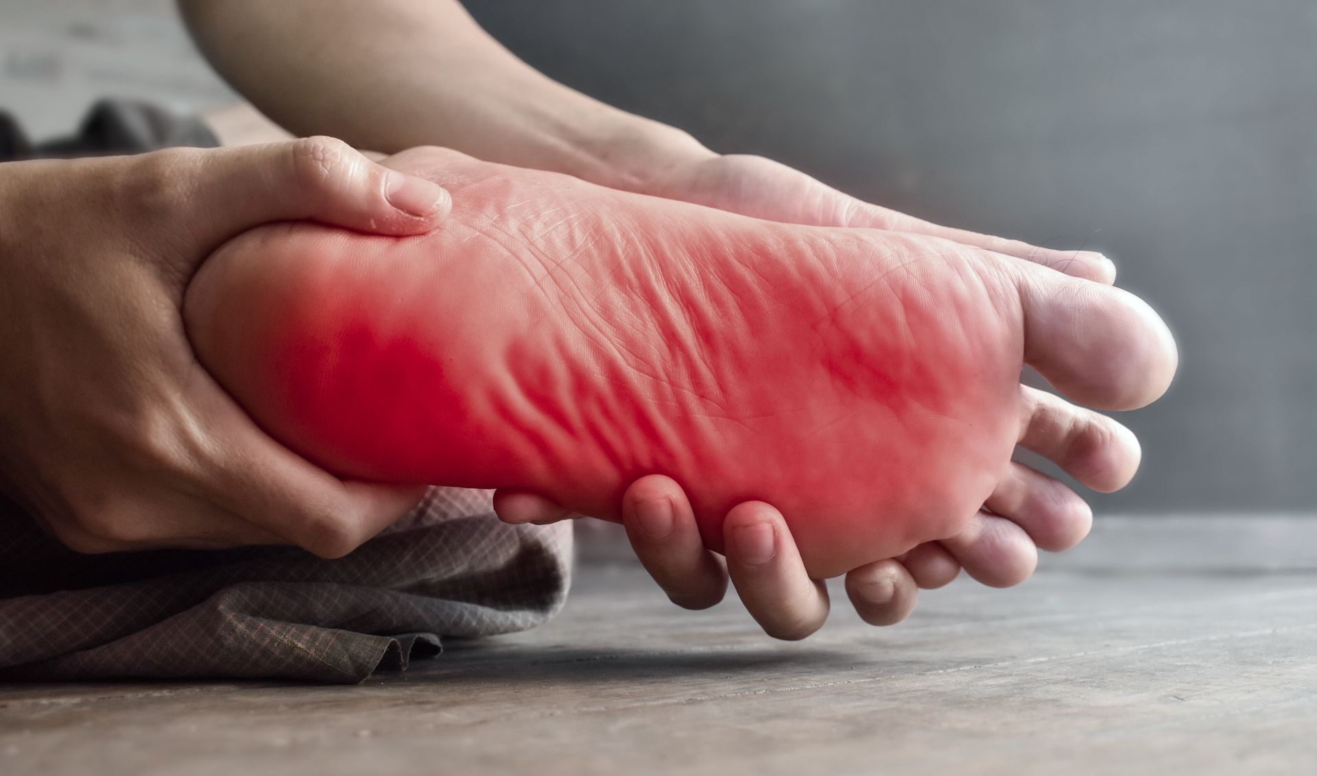 Person holding inflamed foot showing symptoms of plantar fasciitis pain and heel discomfort. Person holding inflamed foot showing symptoms of plantar fasciitis pain and heel discomfort.