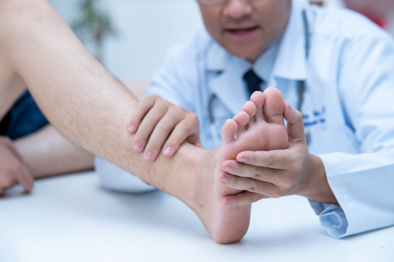 Healthcare professional examining a patient’s foot during a checkup. Healthcare professional examining a patient’s foot during a checkup.