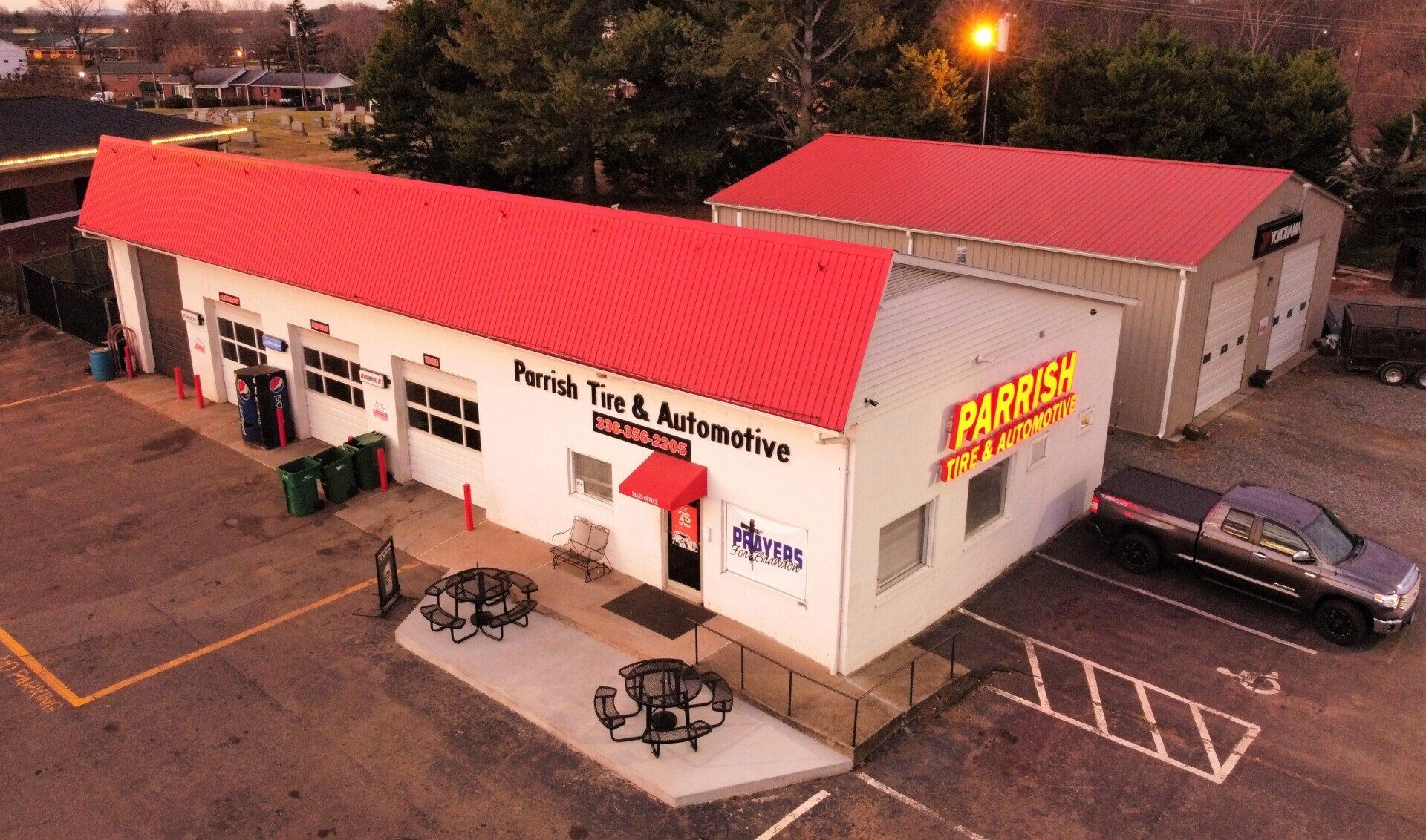 An aerial view of a white building with a red roof