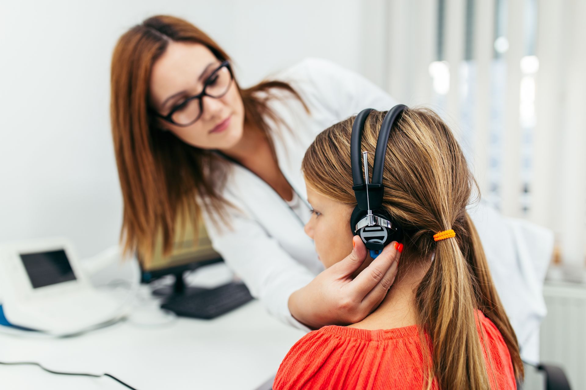 Young girl undergoing a hearing examination with a healthcare professional.