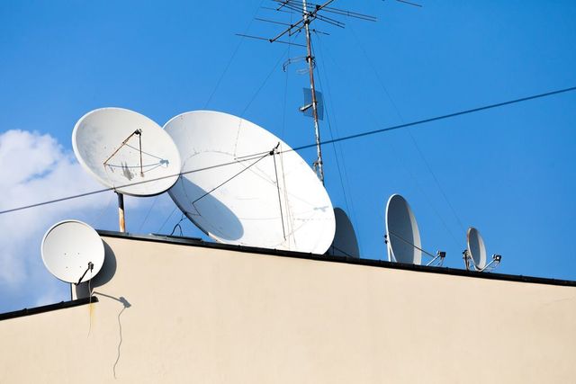 A Bunch of Satellite Dishes on Top of a Building — Garrow's TV & Antenna Services in Caloundra West, QLD