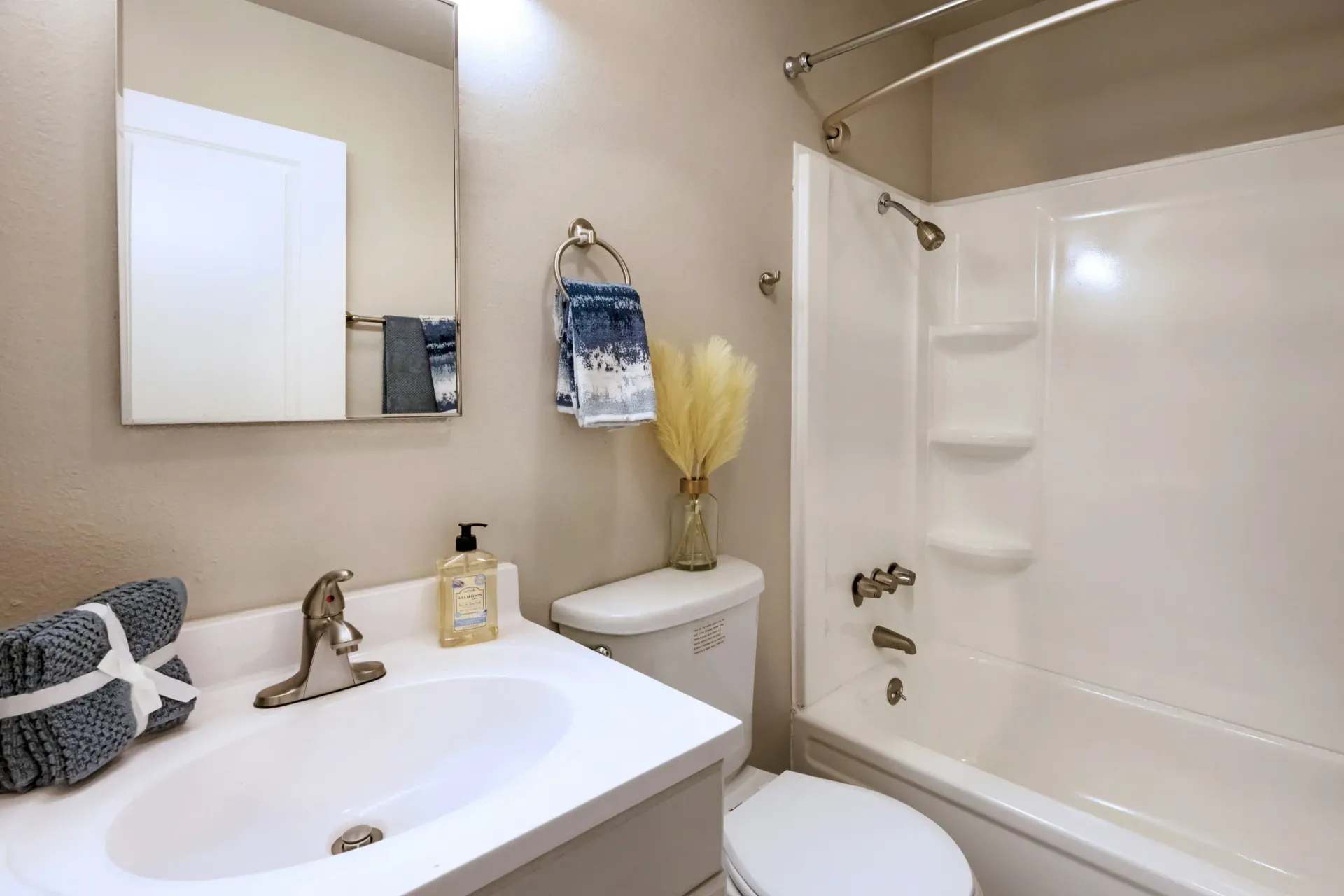 Bathroom with sink, mirror, towels, toilet, and white tub/shower at Marina's Edge.