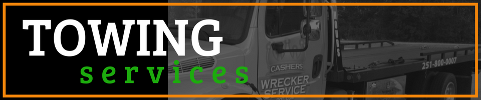 Towing services sign with white and green text on a dark background and a tow truck silhouette