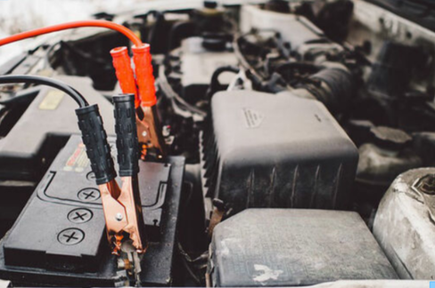 Battery boost with jumper cables connected to a dead battery, positive and negative