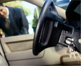Picture of Guy looking in car through drivers window at keys that are in ignition