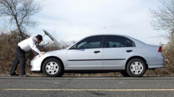 Picture of Guy with Hat on the side of the road looking under his cars hood