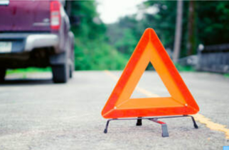 Picture of Red Truck pulled over with safety pylon in foreground