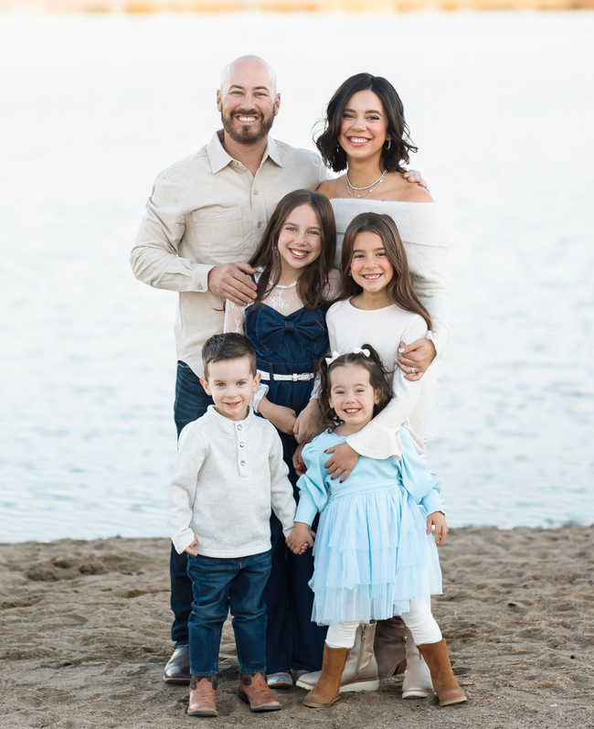 A family is posing for a picture together in a park.