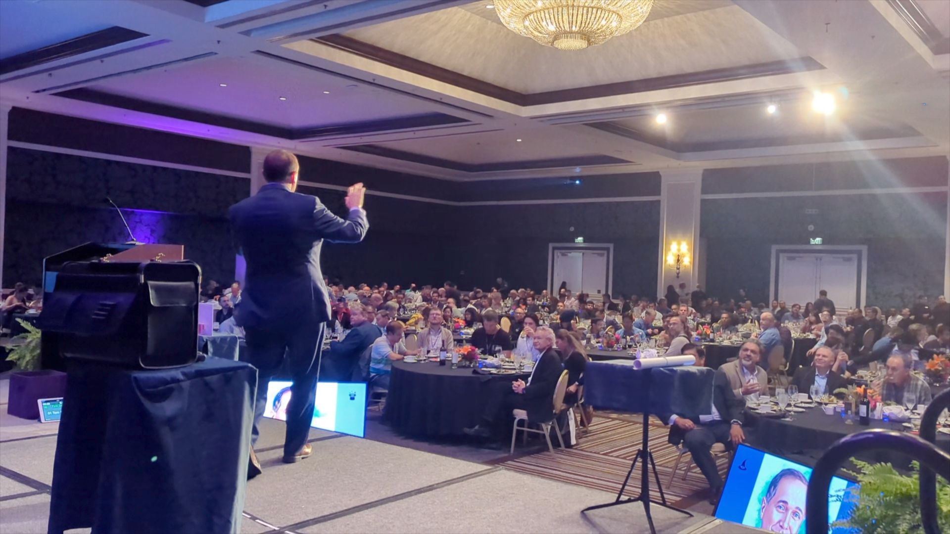 Corporate magician David Martinez performs on stage before a large audience