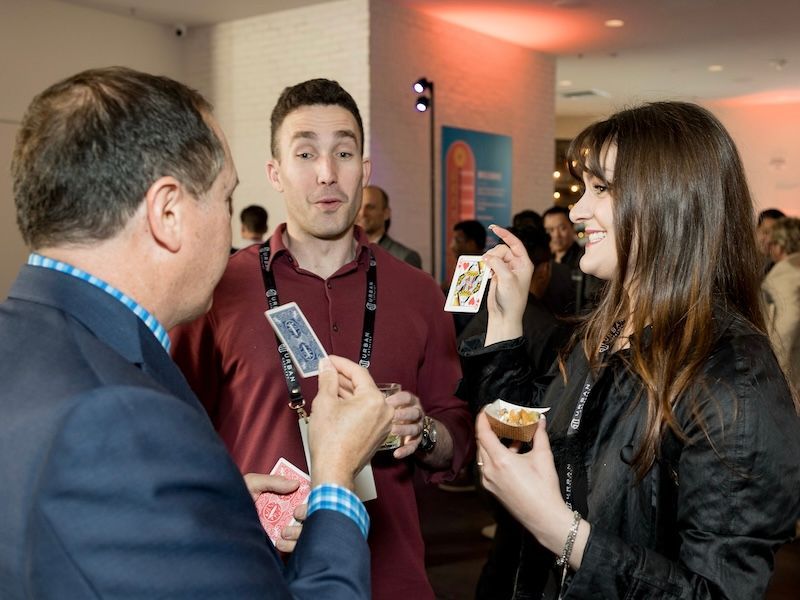 San Francisco Bay Area magician David Martinez performs a magic trick for two attendees of a corporate event.