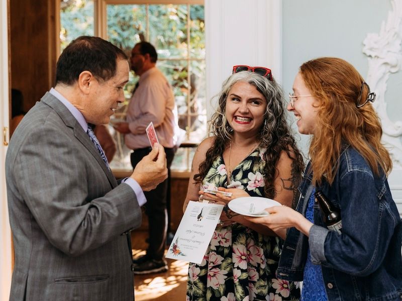 Magician David Martinez entertains two people at a house party