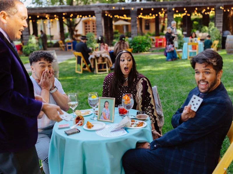 Party magician David Martinez wows a guest at an outdoor event.