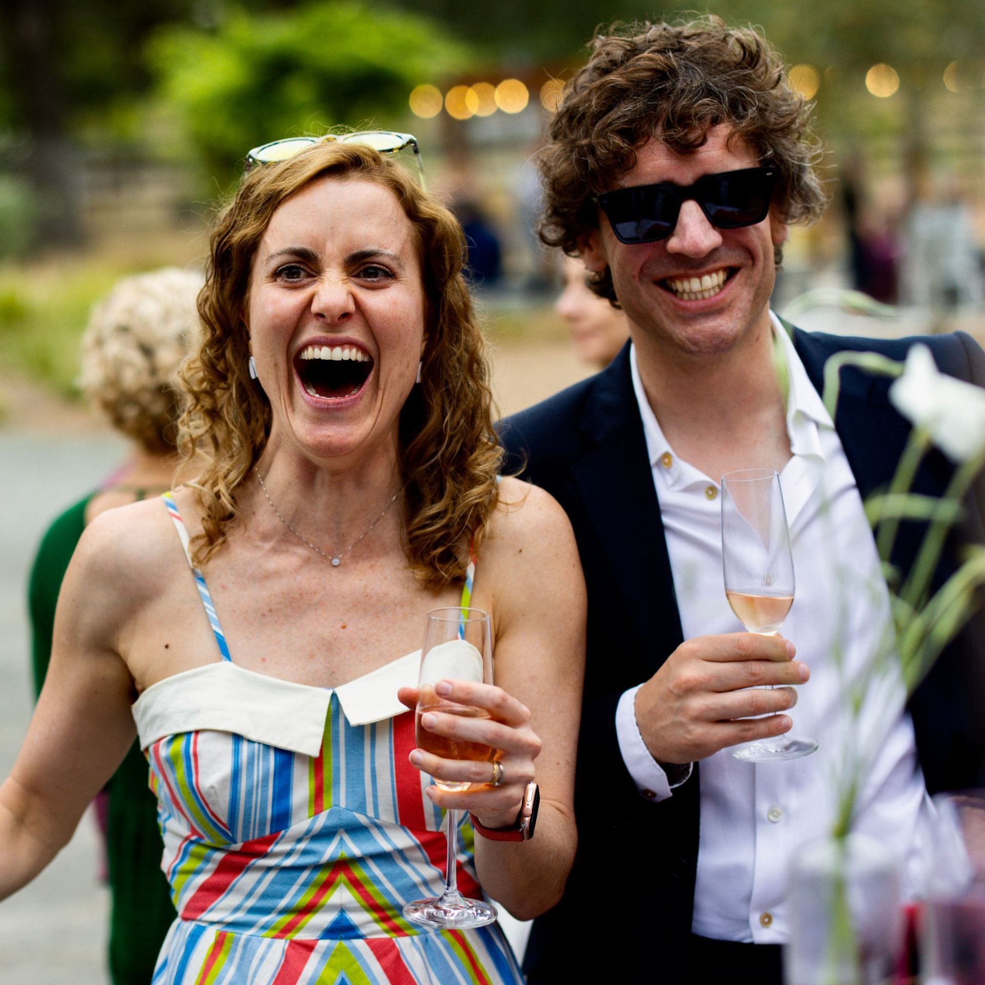 Guests laughing at magic performed by David Martinez at an outdoor event
