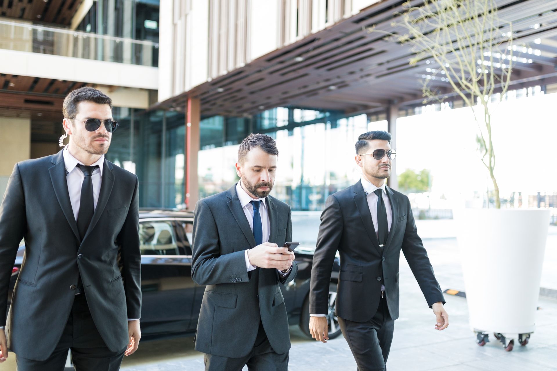 Personal security guard services with two bodyguards protecting a businessman in the city